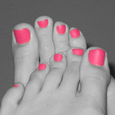 A photograph of two small overlapping feet, all in greyscale except for the pink toenails.